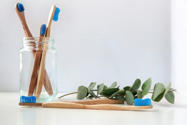 The Importance of Going to Dentist blue and white toothbrush in clear glass jar